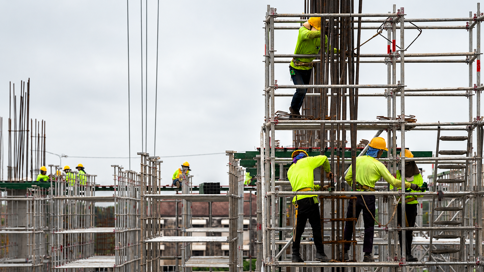 Equipe com EPI montando andaime tubo roll em torno de pilares de concreto em obra, ilustrando a divisao de responsabilidade entre contratante e locadora
